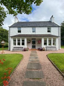 The outside of Millburn B & B with flowering garden pots